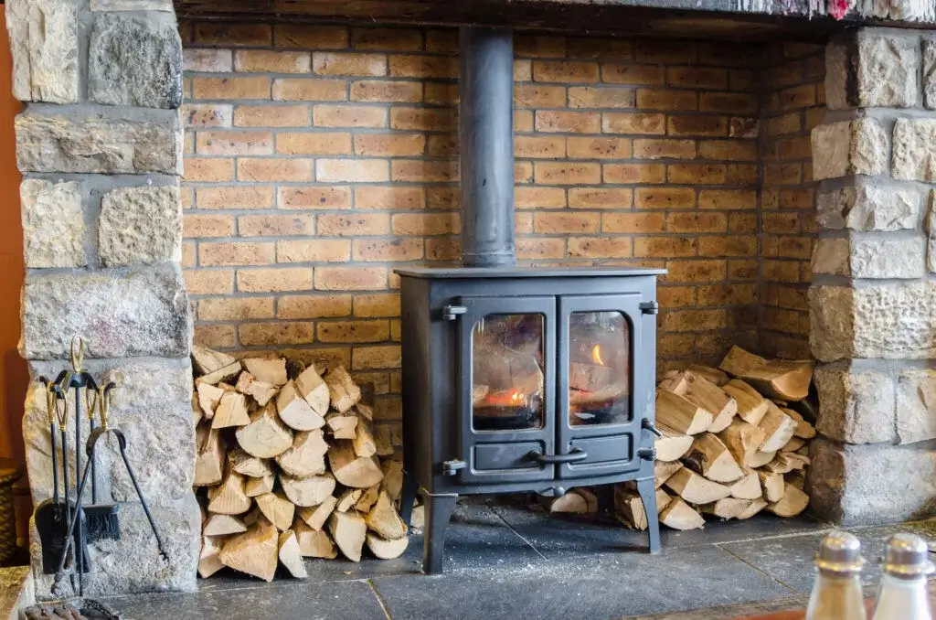 kiln dried wood logs by the side of a stove